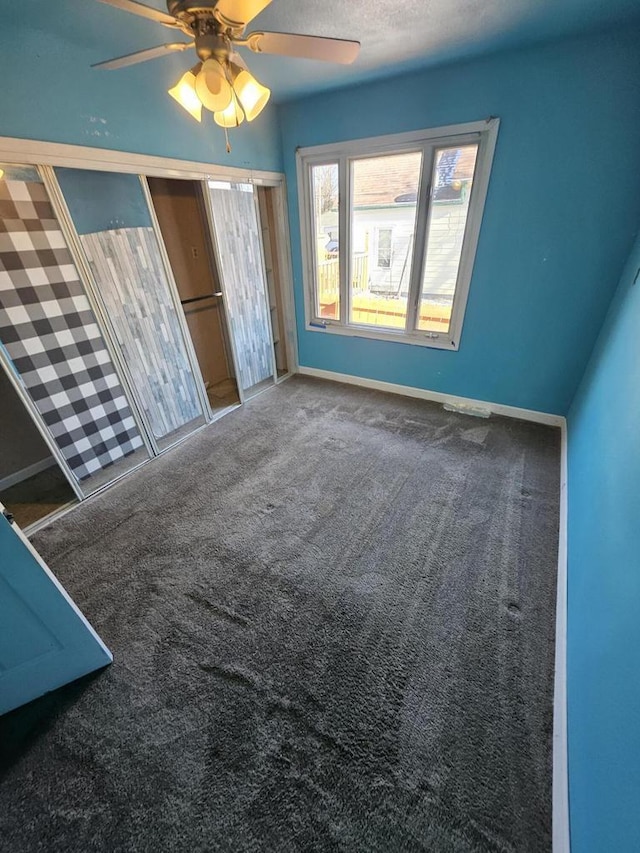 unfurnished bedroom with baseboards, a ceiling fan, and carpet flooring