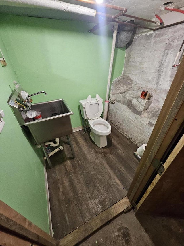 bathroom with a sink, toilet, and wood finished floors