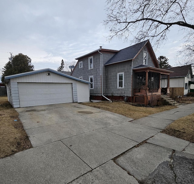 view of property exterior with a detached garage and an outbuilding