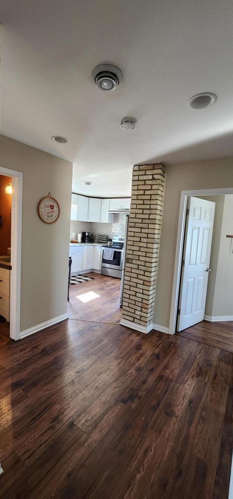 corridor featuring dark wood-style floors and baseboards