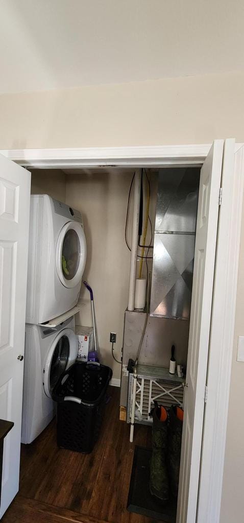 washroom featuring laundry area, stacked washer and clothes dryer, and wood finished floors