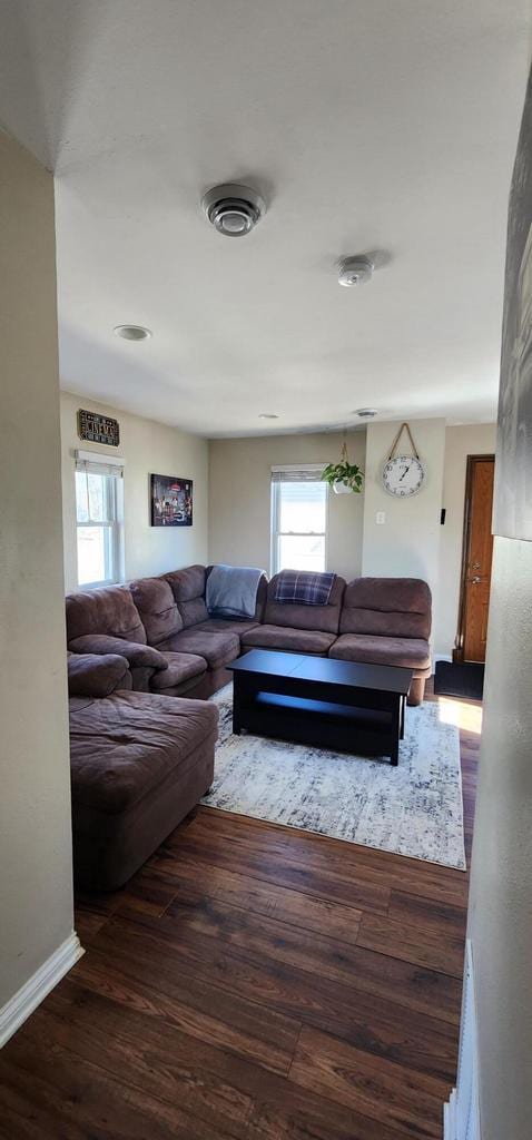 living area with visible vents, wood finished floors, and baseboards