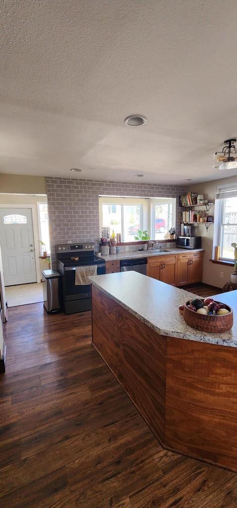 kitchen featuring dark wood-style floors, a textured ceiling, stainless steel appliances, and a sink