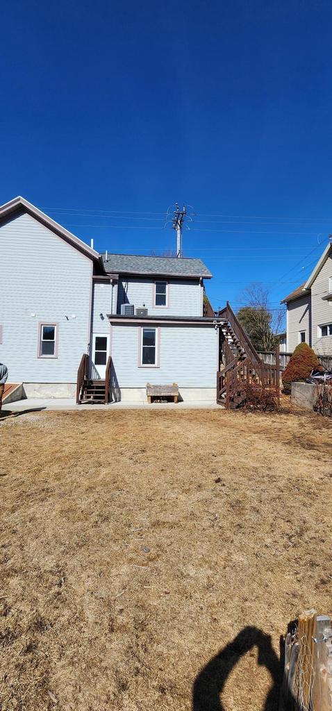 rear view of house with a yard and entry steps