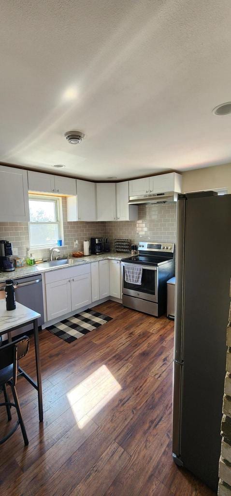 kitchen with tasteful backsplash, appliances with stainless steel finishes, and white cabinetry