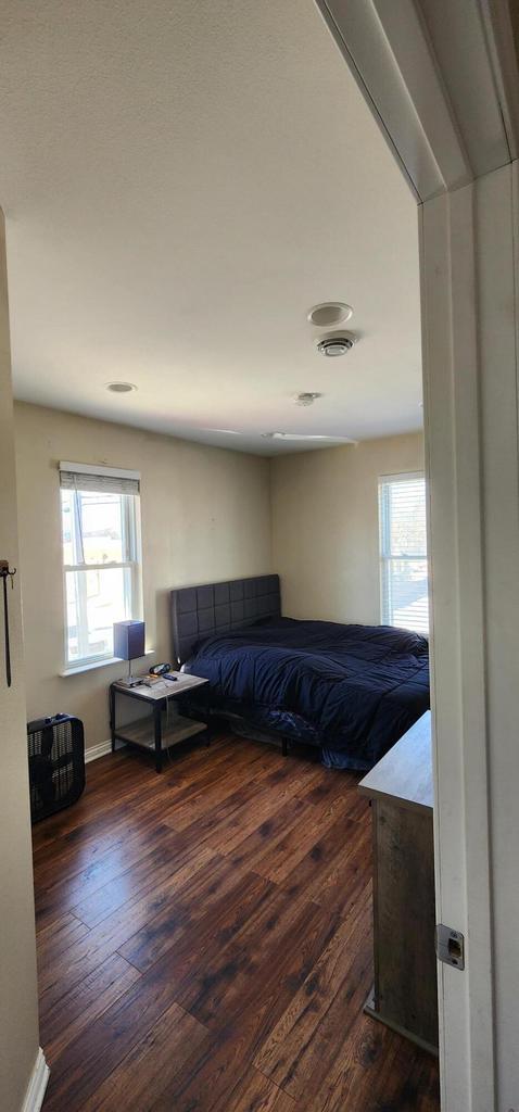 bedroom featuring visible vents, baseboards, and wood-type flooring