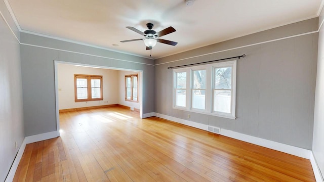 unfurnished room featuring visible vents, ornamental molding, a ceiling fan, light wood finished floors, and baseboards