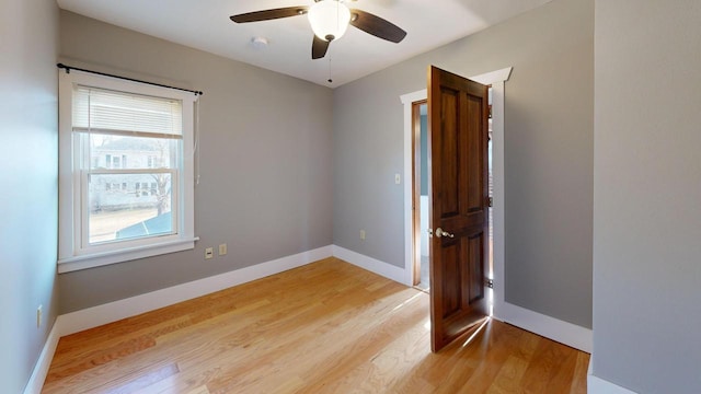 unfurnished room with baseboards, ceiling fan, and light wood finished floors