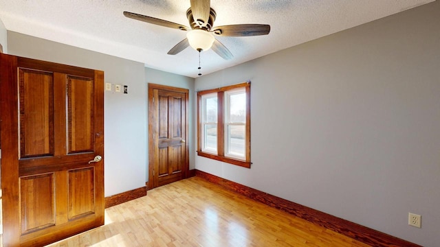 unfurnished bedroom featuring baseboards, a textured ceiling, ceiling fan, and light wood finished floors