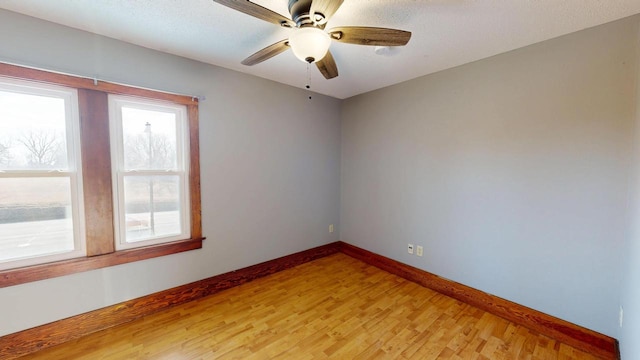 unfurnished room with baseboards, a ceiling fan, and light wood finished floors