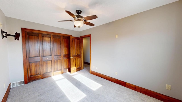 unfurnished bedroom with visible vents, light carpet, baseboards, and ceiling fan