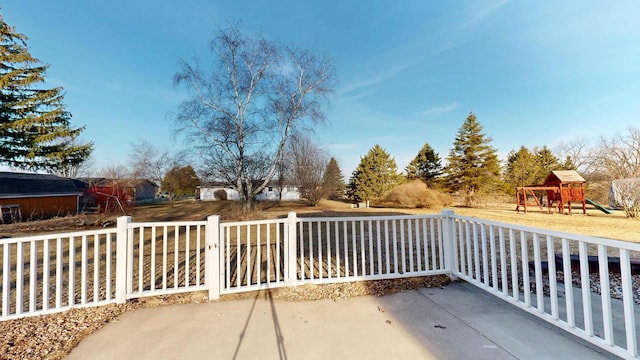 view of patio with fence and a playground