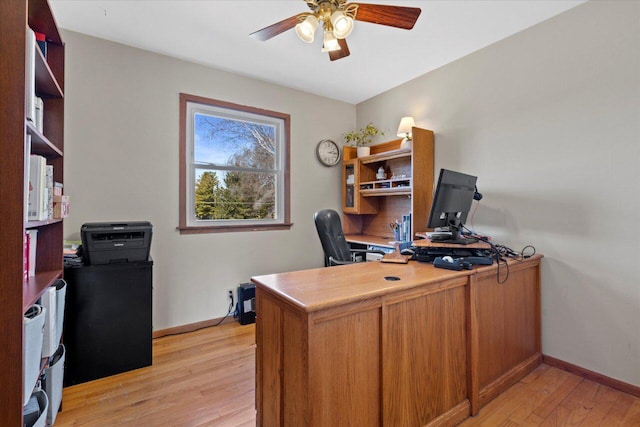 office featuring baseboards, light wood-type flooring, and ceiling fan