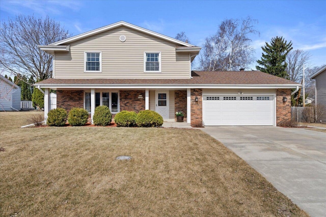 traditional-style house with a garage, driveway, brick siding, and a front yard