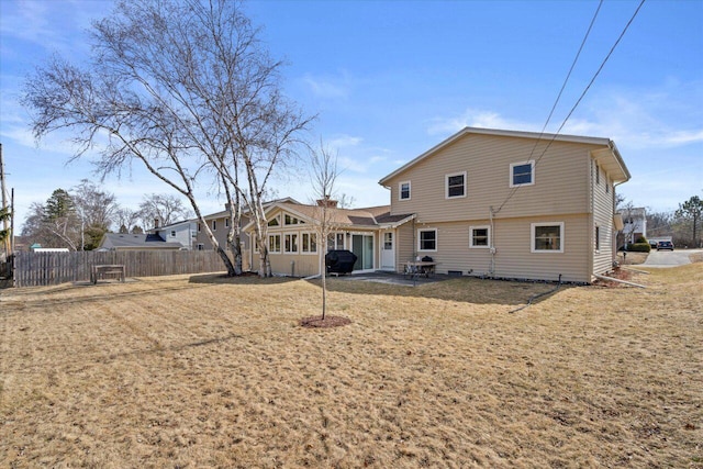 rear view of house featuring a yard, a patio, and fence