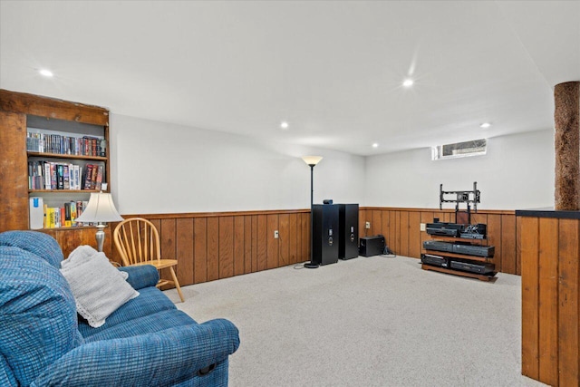 living area featuring recessed lighting, carpet flooring, wooden walls, and wainscoting