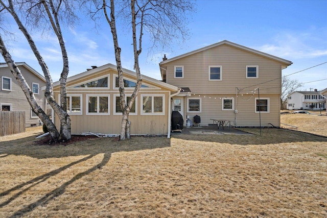 back of property featuring a yard, a patio, and fence