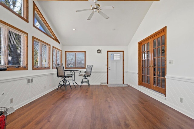 sitting room with visible vents, ceiling fan, a wainscoted wall, vaulted ceiling, and wood finished floors