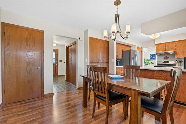 dining space featuring wood finished floors and a chandelier