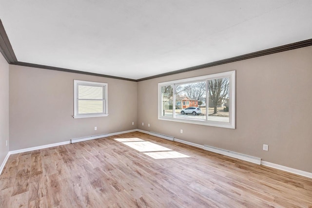 spare room featuring a wealth of natural light, baseboards, and wood finished floors