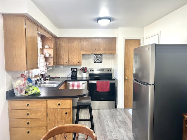 kitchen with a sink, open shelves, dark countertops, appliances with stainless steel finishes, and decorative backsplash