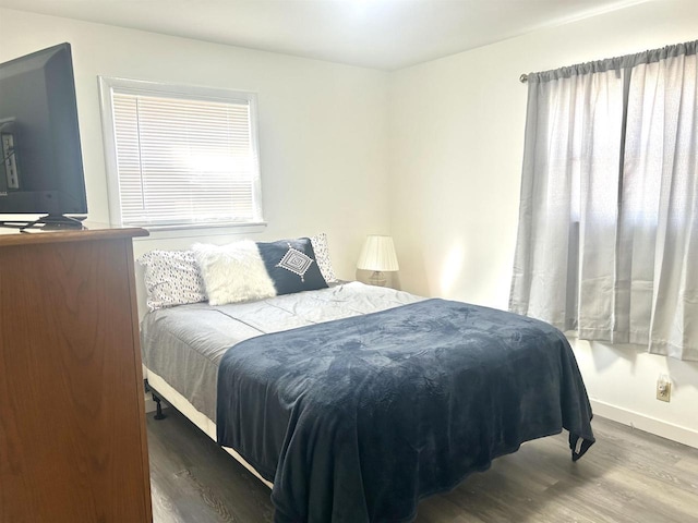 bedroom with baseboards and wood finished floors