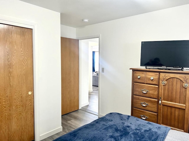 bedroom with baseboards and wood finished floors