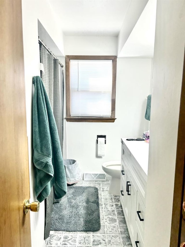 full bathroom with vanity, a shower with shower curtain, toilet, and visible vents