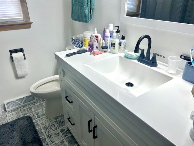 bathroom with visible vents, toilet, vanity, and tile patterned flooring