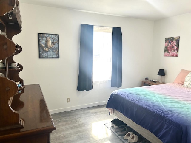 bedroom featuring wood finished floors and baseboards