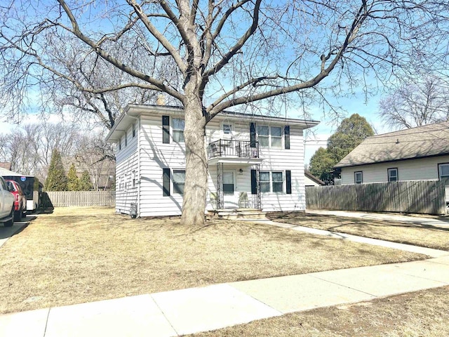 view of front of property with a balcony and fence