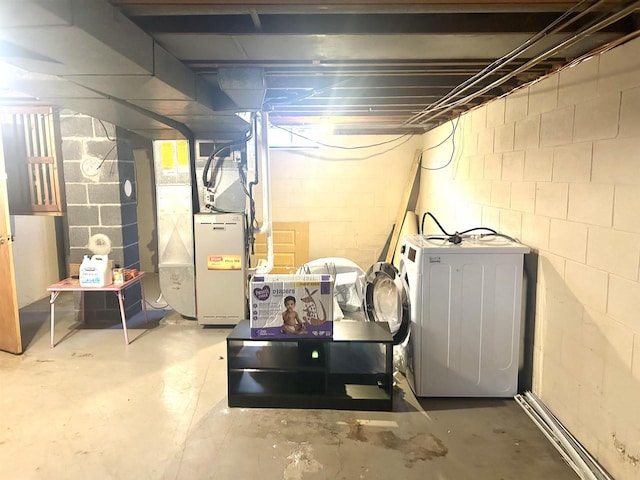 unfinished basement featuring heating unit and washer / dryer