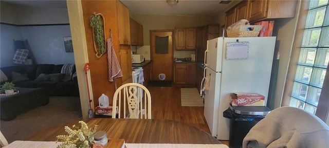 kitchen with white appliances, wood finished floors, and brown cabinetry