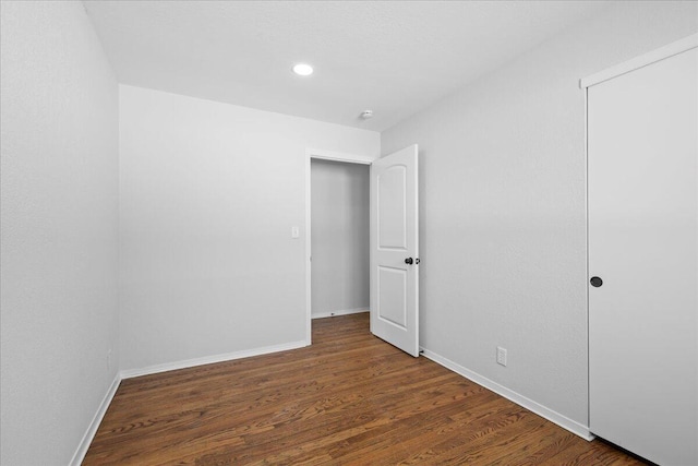 unfurnished bedroom with recessed lighting, wood finished floors, and baseboards