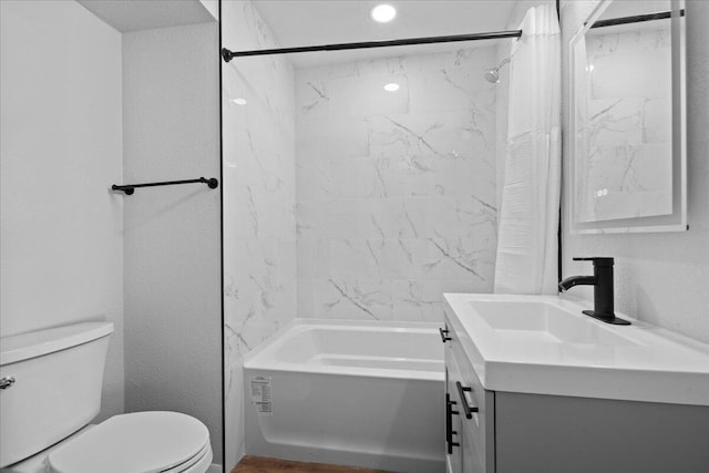 bathroom featuring toilet, vanity, shower / tub combo, and a textured wall