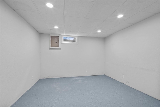 basement with electric panel, a paneled ceiling, and recessed lighting