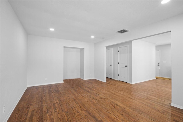 empty room with visible vents, recessed lighting, baseboards, and wood finished floors