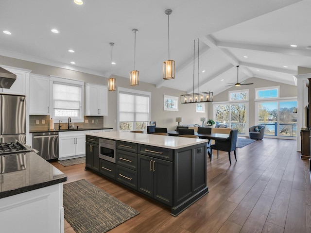 kitchen featuring backsplash, white cabinets, dark wood finished floors, and stainless steel appliances