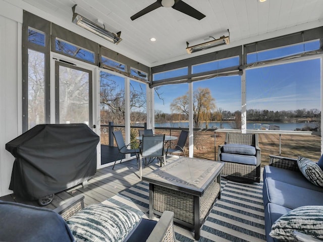 sunroom / solarium with ceiling fan and a water view