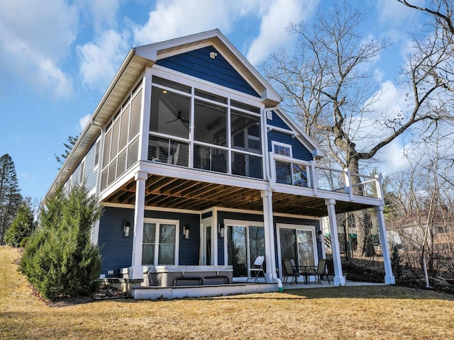 back of house with a lawn, a patio, and a sunroom