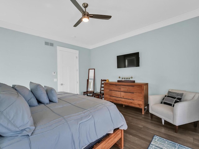 bedroom with crown molding, wood finished floors, visible vents, and ceiling fan