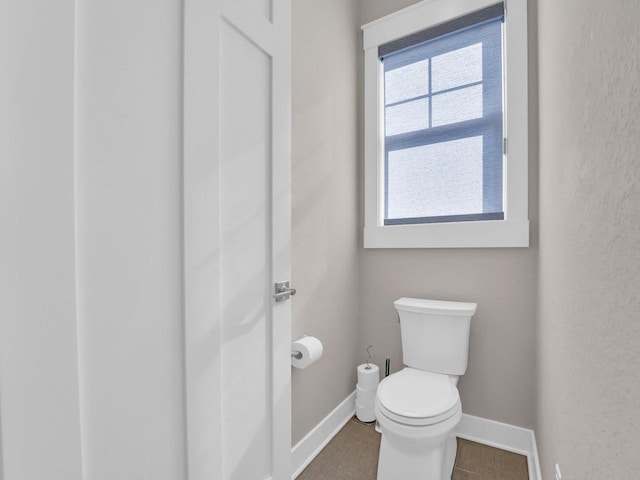 bathroom with toilet and baseboards