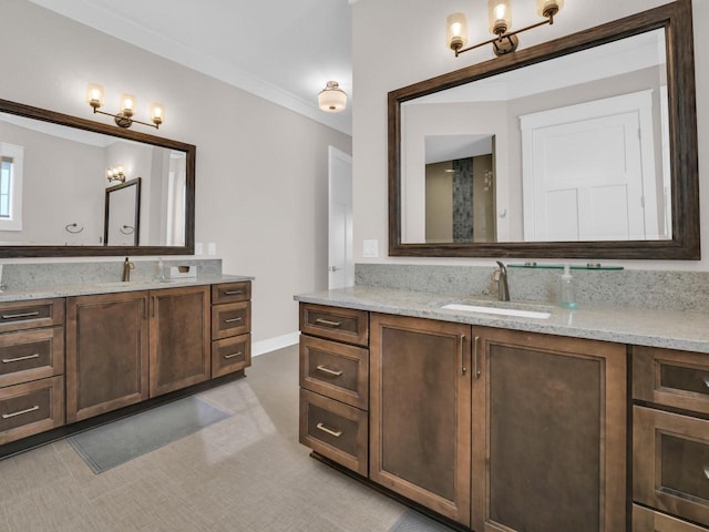 full bathroom featuring crown molding, two vanities, baseboards, and a sink