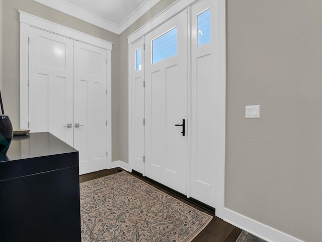 entryway featuring baseboards, dark wood-type flooring, and ornamental molding