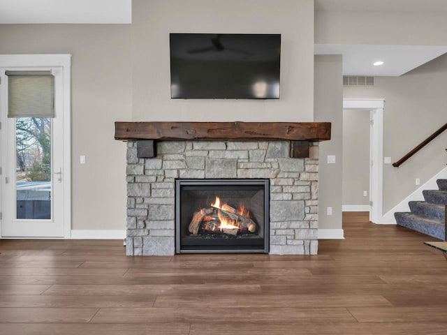 details featuring wood finished floors, visible vents, baseboards, recessed lighting, and a stone fireplace