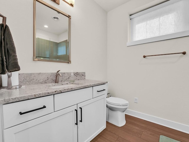 full bath featuring a shower stall, baseboards, toilet, wood finished floors, and vanity