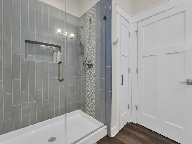 full bath with a shower stall and wood finished floors