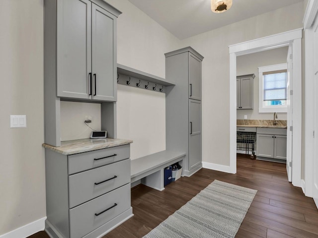 mudroom with a sink, baseboards, dark wood-style floors, and built in study area