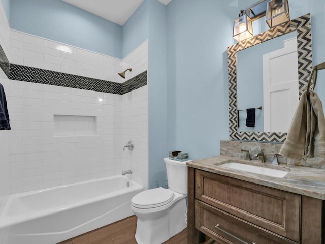 bathroom featuring shower / bathtub combination, toilet, vanity, and wood finished floors