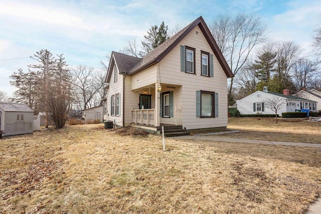 view of front of property featuring an outbuilding, a storage unit, covered porch, and roof with shingles